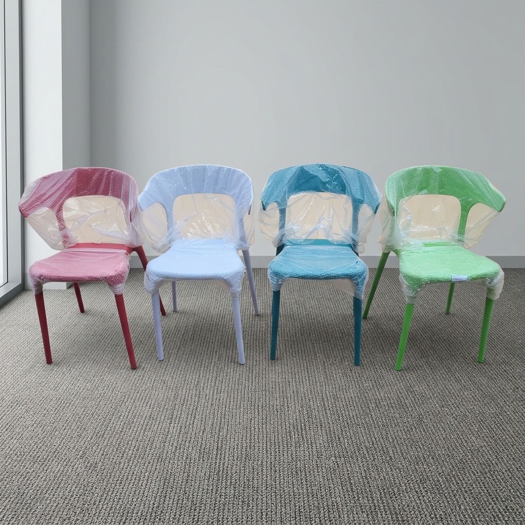 Stackable molded plastic dining armchairs in pastel pink, light blue, teal, and lime green wrapped in protective plastic film.