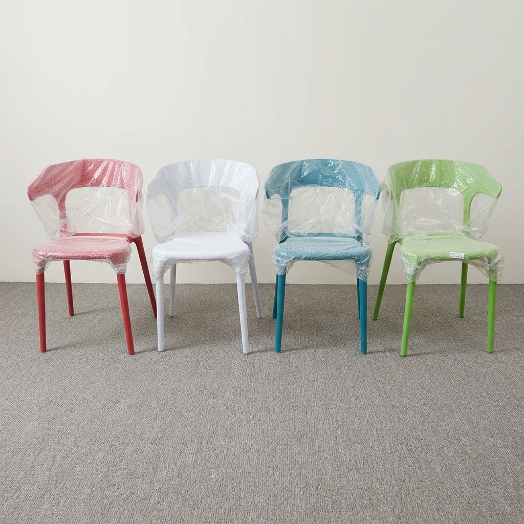 Stackable molded plastic dining armchairs in pastel pink, light blue, teal, and lime green wrapped in protective plastic film.