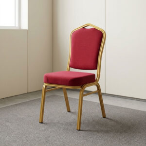 Red upholstered stackable banquet conference chair with padded seat, contoured backrest, integrated handle cutout, and gold metal frame.